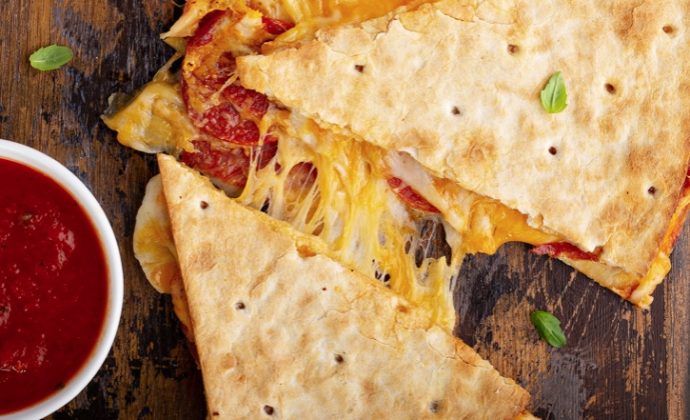 This fun and easy dinner recipe is a hit with my kids! Turn quesadillas into pizza with pepperoni and other classic pizza toppings, and then serve with pizza sauce.