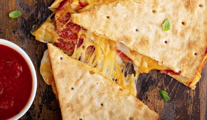 This fun and easy dinner recipe is a hit with my kids! Turn quesadillas into pizza with pepperoni and other classic pizza toppings, and then serve with pizza sauce.