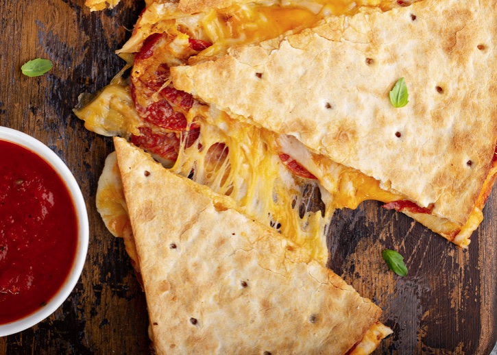 This fun and easy dinner recipe is a hit with my kids! Turn quesadillas into pizza with pepperoni and other classic pizza toppings, and then serve with pizza sauce.