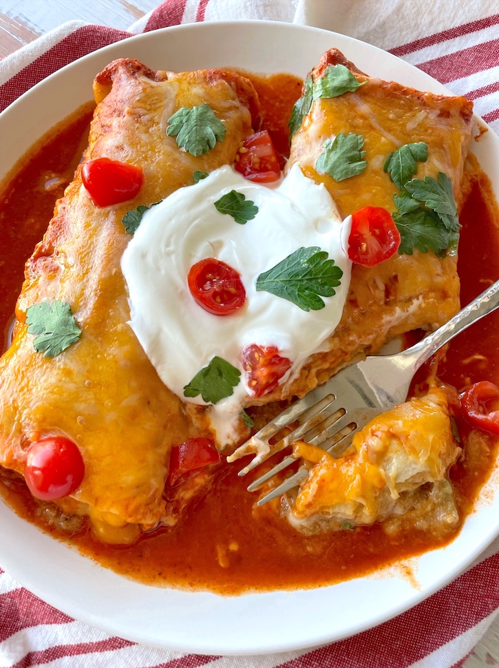 Do you have a large picky family to feed? You've got to try this food hack! Simply smother frozen burritos in enchilada sauce and cheese, and then bake for the easiest meal you'll ever make! My kids love this simple meal, and I love making it on busy school nights. 