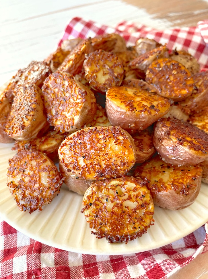 The best potato side dish for dinner! This quick and easy oven roasted red potato recipe is awesome! They're literally swimming in butter so they get super soft in the middle with a crispy and cheesy crust. Serve them with chicken, steak, bbq, and more! My picky kids love them. 