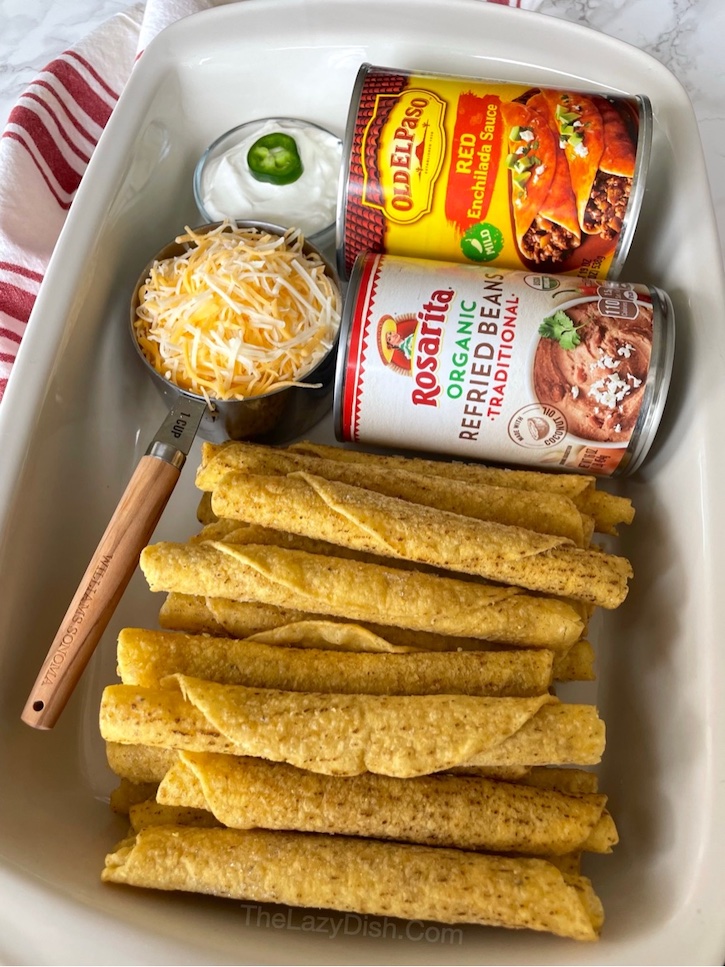 Frozen Taquito Dinner Casserole | This is basically a lazy way of making enchiladas! It's so easy, anyone can make it, yet it tastes like something you'd get at a fancy Mexican restaurant. Just 4 cheap ingredients for this simple meal: frozen taquitos (chicken or beef), enchilada sauce, refried beans, and cheese. So yummy! My picky eaters love it. 