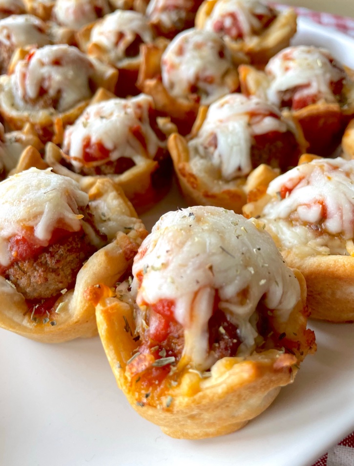 Yummy dinner idea for a family with kids! These mini meatball cupcakes are fun to make in a mini muffin tin with just a few budget friendly ingredients: Pillsbury dough, frozen meatballs, cheese, and pizza sauce! They make for a wonderful quick meal as well as a filling snack for afters school. Great for sleepovers!