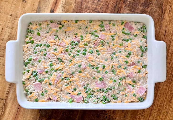 Step one for making a cheesy rice ham and pea casserole in a 9x13 baking dish. 