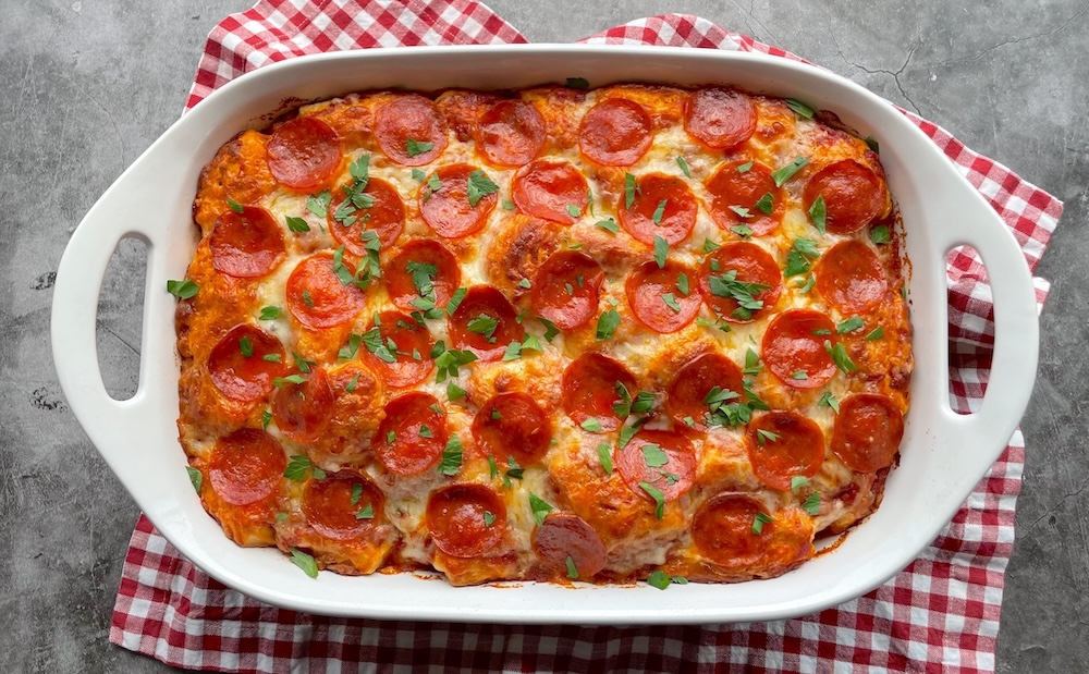 This easy dinner recipe is made with refrigerated biscuits, pizza sauce, cheese and pepperoni, all tossed together in a large baking dish to make a quick family meal for busy weeknights.