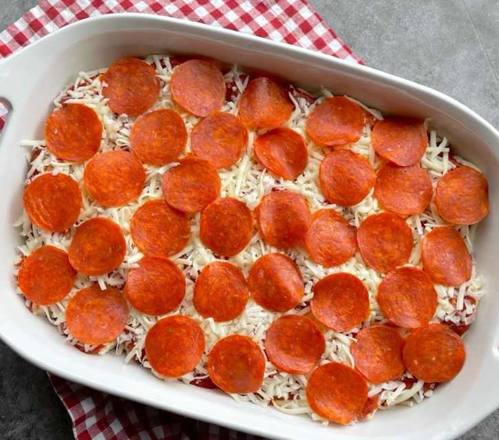 A yummy pizza casserole ready for the oven! This easy meal is topped with lots of pepperoni and cheese, making for a delicious family meal on busy school nights. 