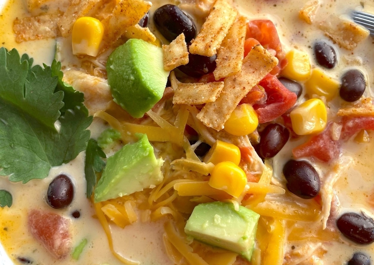 This creamy chicken taco soup is easy and inexpensive to make in a slow cooker with just a few ingredients. A great family dinner recipe, especially for picky eaters.