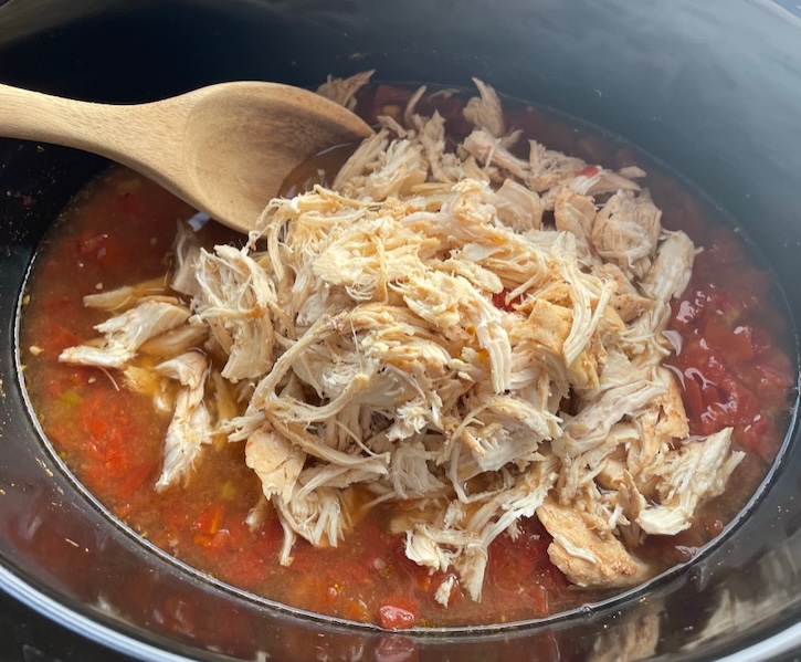 Shredded chicken breasts in a crockpot with an easy to make taco soup recipe. 