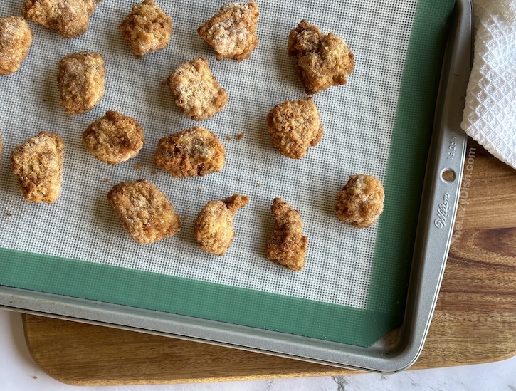 Frozen chicken nuggets on a baking sheet for making homemade Chick-fil-A chicken mini sandwiches, an easy copycat recipe for breakfast.