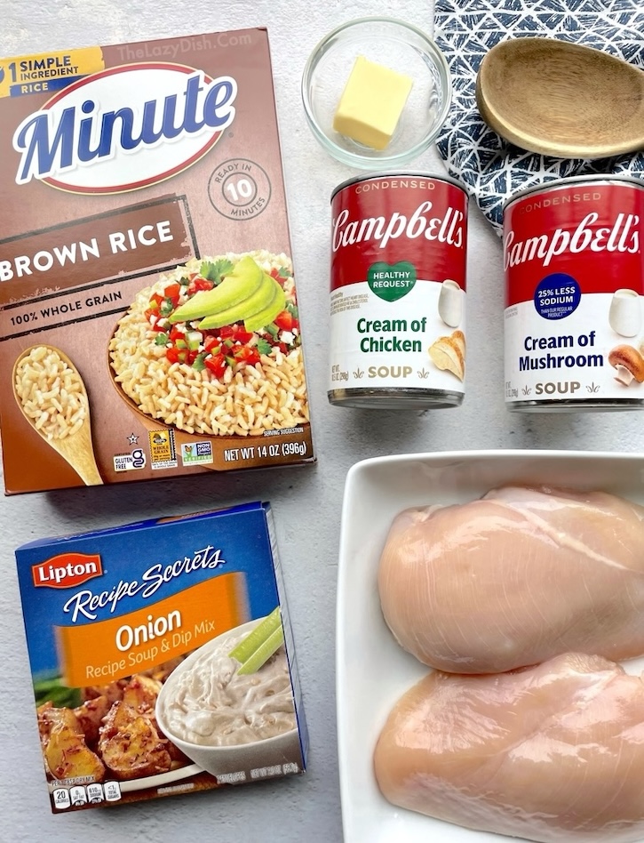 Ingredients needed to make classic forgotten chicken recipe, an easy dinner casserole for large families: chicken breasts, Instant rice, cream of chicken soup, cream of mushroom soup, butter, and an onion soup mix seasoning packet. 