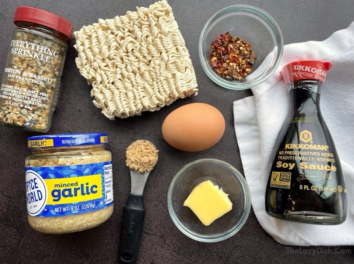 Ingredients to make a sweet and spicy vegetarian Ramen noodle recipe that includes instant ramen, garlic, soy sauce, butter, egg, brown sugar, red pepper, and everything bagel seasoning. 