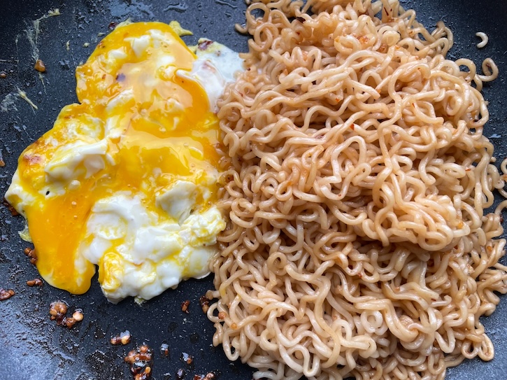 Scrambled egg with cooked ramen noodles. 