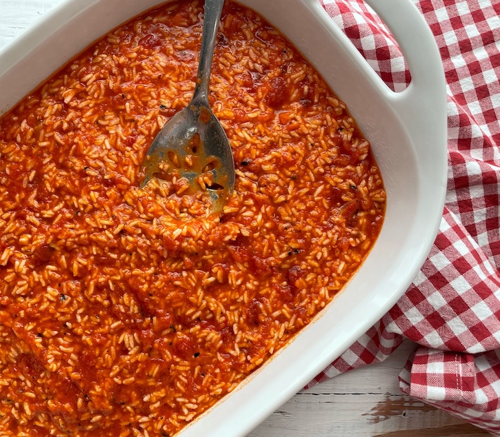 Minute Instant white rice mixed with pasta sauce and diced tomatoes in a large baking dish. 