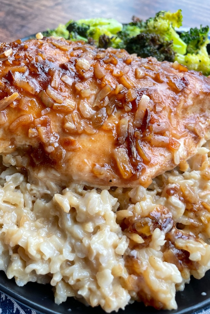 Close up picture of Forgotten Chicken, a quick and easy dinner casserole made with creamy rice and chicken breasts, seasoning with a packet of onion soup mix. 