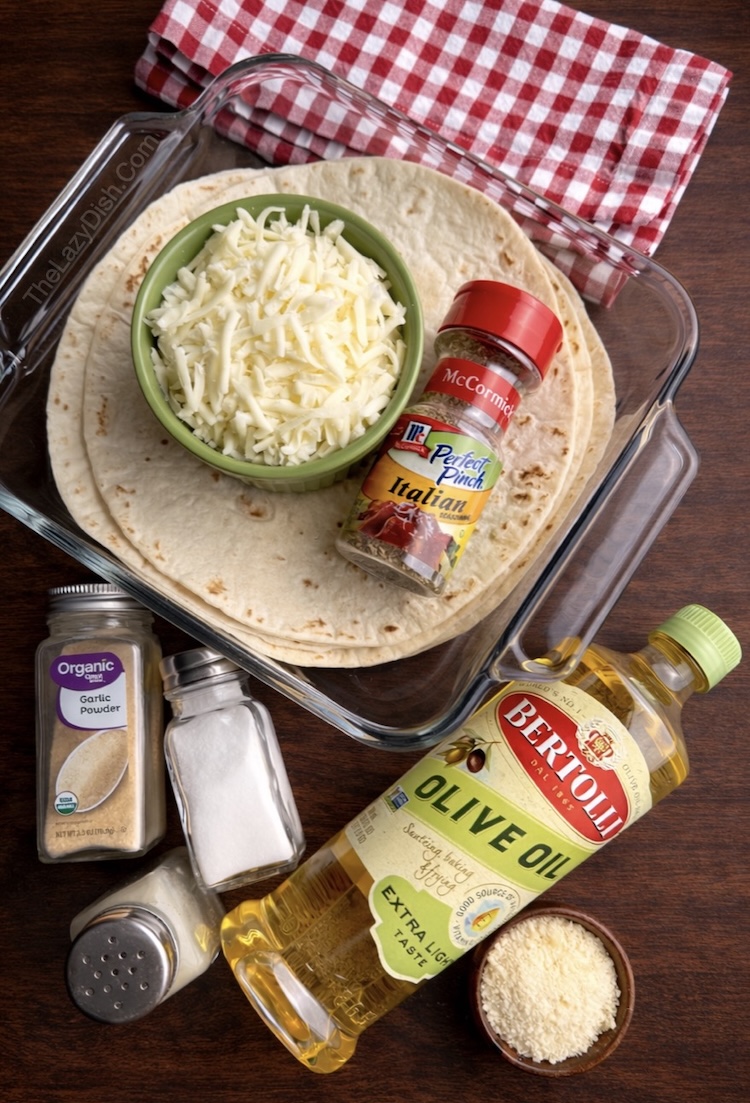 Close up view of ingredients needed to make cheesy pull apart tortilla garlic bread including soft taco size flour tortillas, cheese, olive oil, and seasoning.