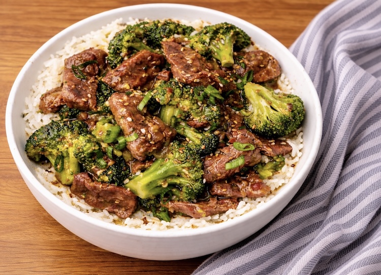 Juicy beef and broccoli over rice in a bowl just out of the crockpot. 