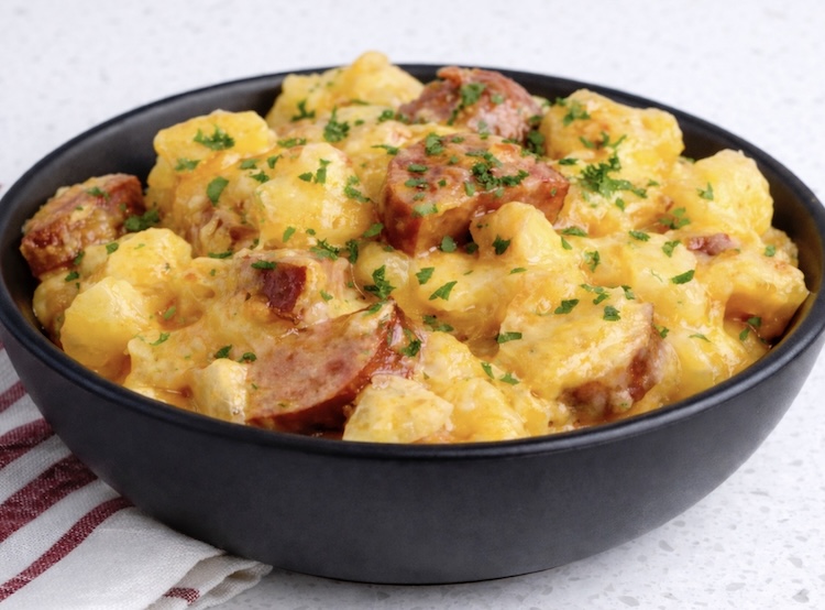 Cheesy sausage and potato casserole in a bowl ready to eat. 